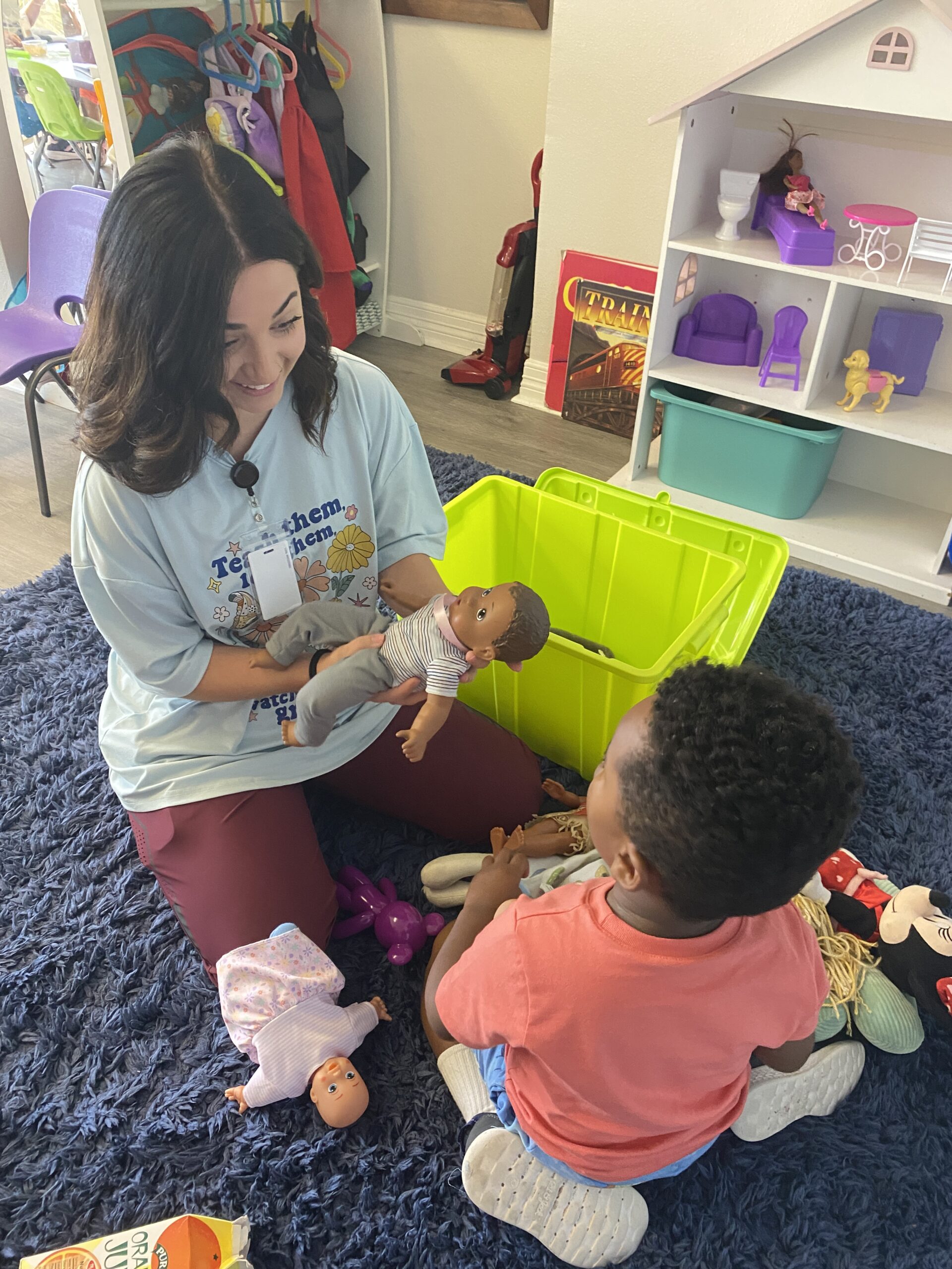 Woman and child playing with dolls on a carpet in a cozy room.