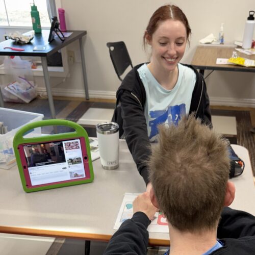 Two people interacting with a tablet device.